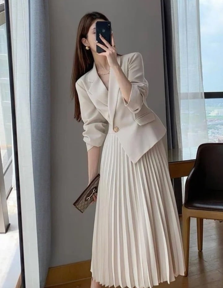 Chân váy xếp ly phối cùng áo blazer.