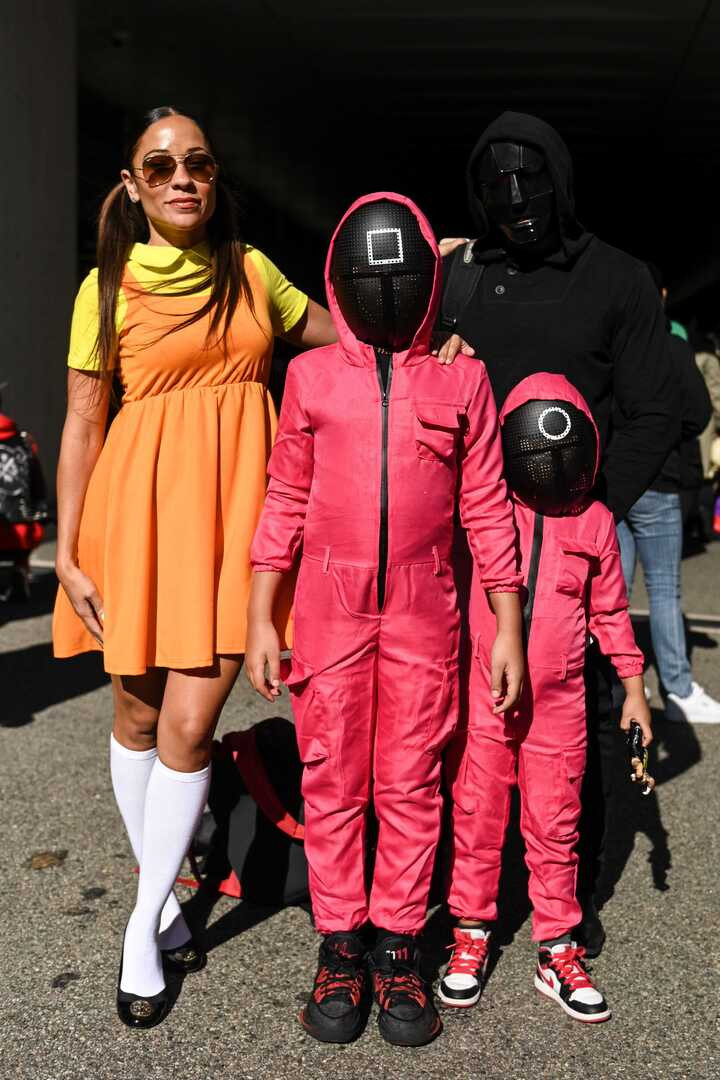 Lấy cảm hứng từ nhân vật Young-hee trong Squid Game, bạn có thể dễ dàng tái hiện tạo hình búp bê khổng lồ đáng sợ bằng những món đồ quen thuộc: váy màu cam, áo vàng ngắn tay và đôi tất trắng cao. Ý tưởng này càng thú vị hơn nếu bạn rủ thêm bạn bè hoặc các bé cùng hóa trang để tạo thành “nhóm trò chơi sinh tồn” vui nhộn.