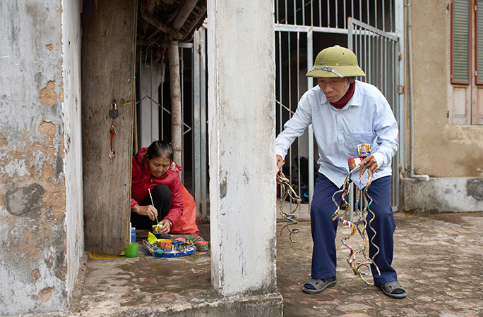 Mr Huyền painting with his wife's help