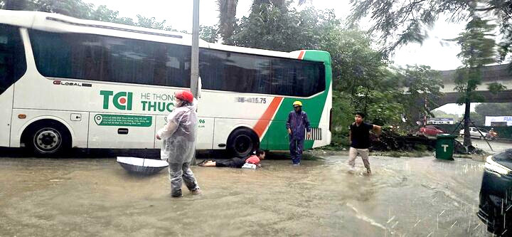 Người dân bị ngã khi đi qua điểm ngập.