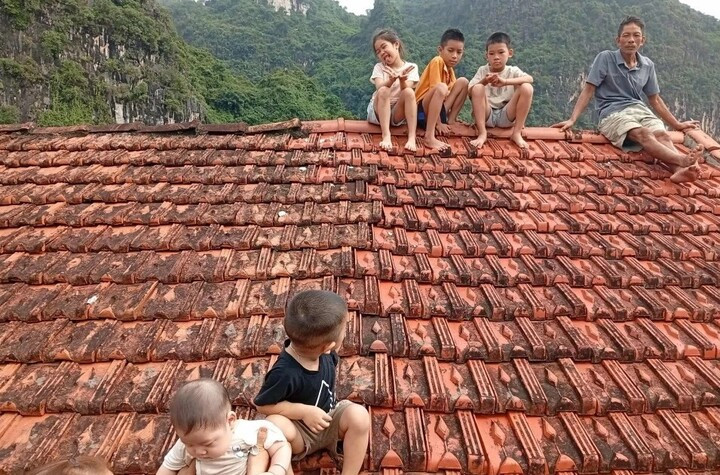 5 đứa trẻ ở xã Vân Nham ngồi trên mái nhà chờ cứu hộ tiếp tế.