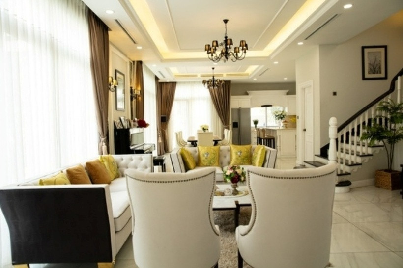 Nữ MC tô điểm thêm cho không gian phòng khách bằng đèn chùm, lọ hoa và gối tự tông vàng đất.