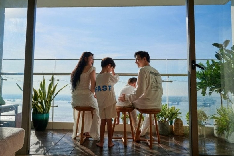 Ban công phòng khách rộng rãi và thoáng đãng, đặt nhiều cây xanh. Cặp đôi sắp xếp thêm ghế để ngồi thư giãn, tận hưởng view sông Đồng Nai tuyệt đẹp. Từ trong nhà nhìn ra phía dòng sông uốn lượn, có thể cảm nhận được sự thanh bình và thư thái.