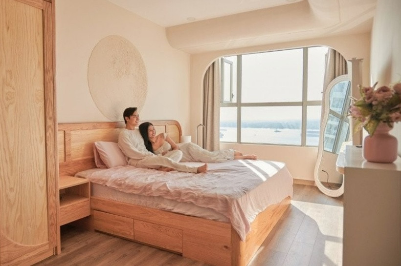 Phòng ngủ của vợ chồng Chúng Huyền Thanh – Jay Quân được bài trí đơn giản với chiếc giường ngủ gỗ, tủ quần áo và kệ sách. Từ cửa sổ của phòng ngủ, cặp đôi vẫn có thể nhìn thấy dòng sông Đồng Nai thơ mộng. Gam màu be nhẹ nhàng cũng tạo cảm giác thư giãn và ấm cúng cho căn phòng.