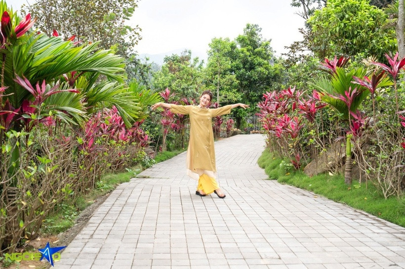 Đường từ cổng đến điện thờ dài hàng trăm mét được lát đá và phủ kín màu sắc của cau vua cùng cây huyết dụ.