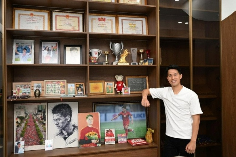 Trên kệ gỗ ngăn cách hai phòng, Đình Trọng trưng bày những bằng khen, huy chương mà anh đạt được cùng những bức ảnh anh thi đấu trên sân cỏ.