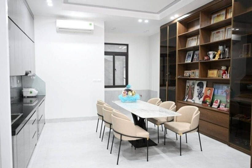 Phòng bếp và phòng khách được ngăn cách bởi một kệ gỗ. Đặc biệt, phòng bếp và phòng ăn cùng mang tông màu sáng giúp không gian thêm rộng rãi và thông thoáng hơn.