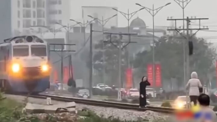 Người phụ nữ thản nhiên tạo dáng mặc cho đoàn tàu tới gần.