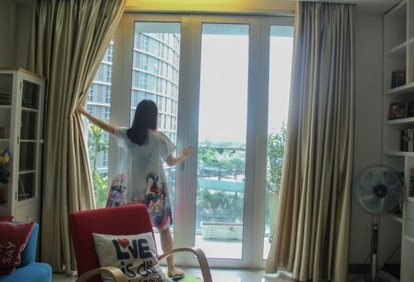 Phòng khách là khu vực thư giãn của cả gia đình, với ban công rộng đón nắng và bộ sofa trắng trang nhã.