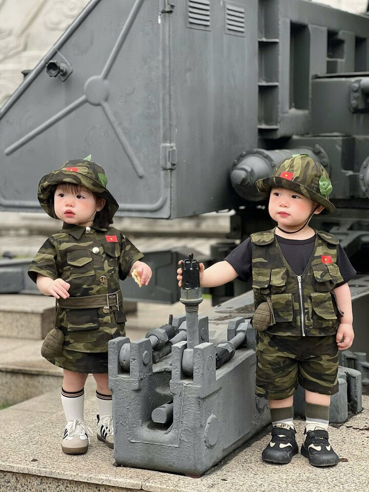 Hai em bé đáng yêu trong bộ quần áo rằn ri bộ đội. (Ảnh: Trang)