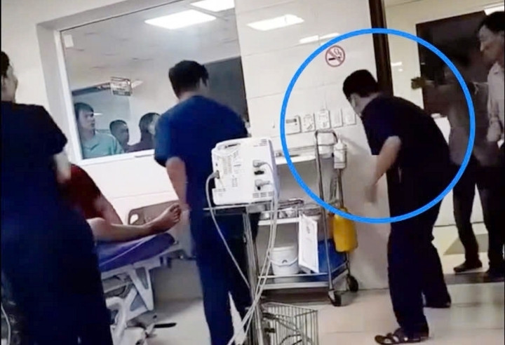Nam điều dưỡng viên bị người nhà bệnh nhân hành hung, đạp vào bụng. (Ảnh cắt từ clip)