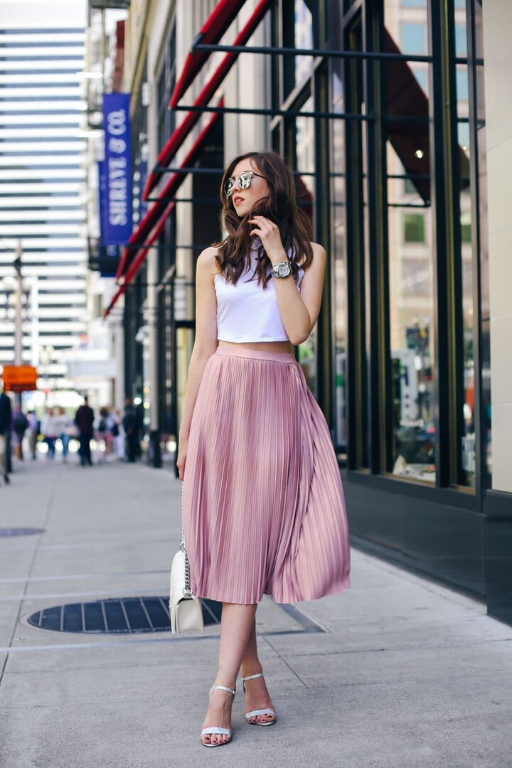 Áo crop top mặc với quần gì, váy gì hợp? Áo crop top kết hợp chân váy xếp ly mang đến sự trẻ trung. (Ảnh: Stylevore)