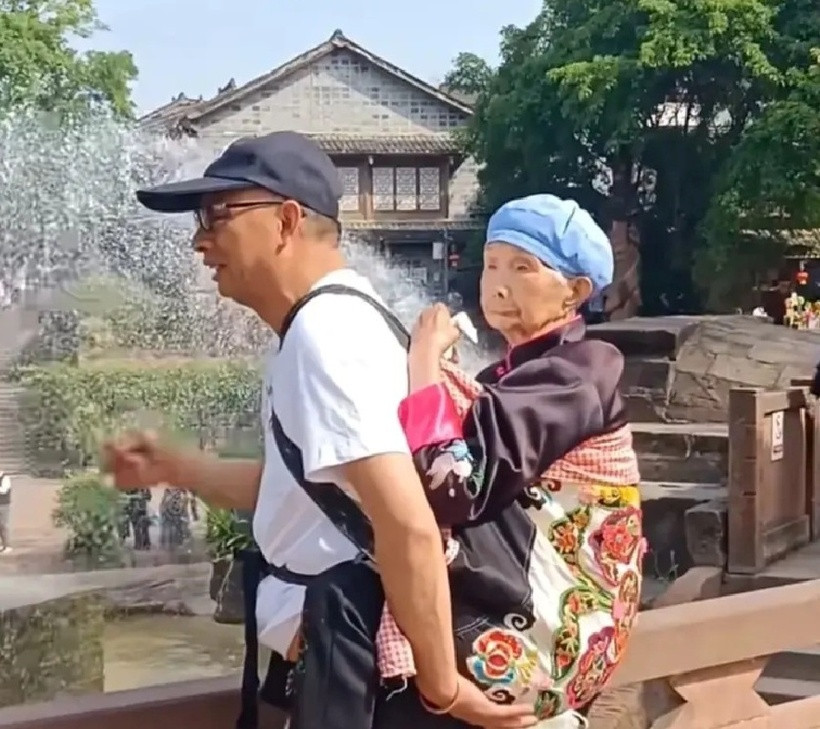 Người mẹ an tâm tựa vào vai con trai, hai người cười nói vui vẻ. Ảnh: Sohu.