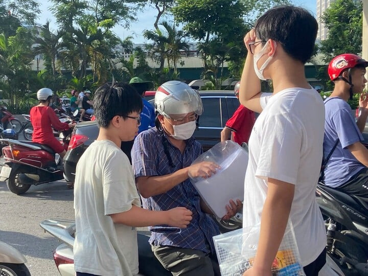 Thí sinh được phụ huynh kiểm tra lại giấy tờ trước khi bước vào phòng thi. (Ảnh: Kim Anh)