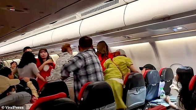 Footage captured the dramatic moment a mid-air brawl broke out among passengers after a group of women refused to stop making noise while the lights were dimmed
