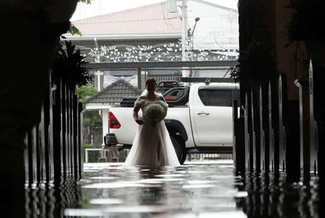 Cặp đôi làm đám cưới giữa dòng nước ngập sau bão gây