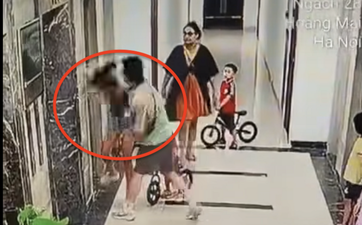 Người phụ nữ bị gã đàn ông hành hung chỉ biết ôm đầu chịu trận. (Ảnh cắt từ clip)