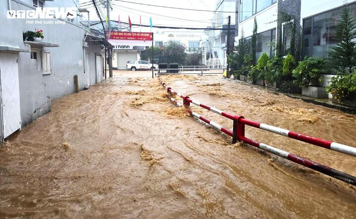 Nước mưa đổ dồn về khu vực hạ lưu suối Cam Ly nhấn chìm cả đường đi bên cạnh.