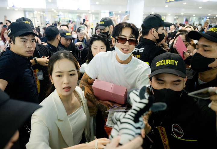 Nam ca sĩ còn đội thử chiếc nón lá ngay tại sân bay trước khi di chuyển về khách sạn.