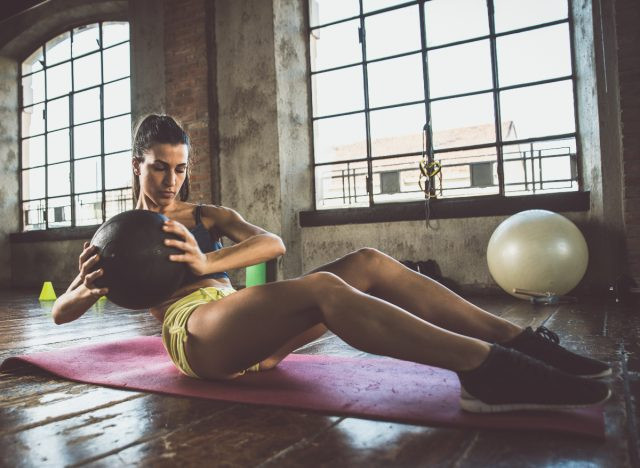 người phụ nữ đang tập động tác xoắn người kiểu Nga, khái niệm về bài tập tốt nhất để giảm mỡ bụng và có cơ bụng săn chắc ngay lập tức