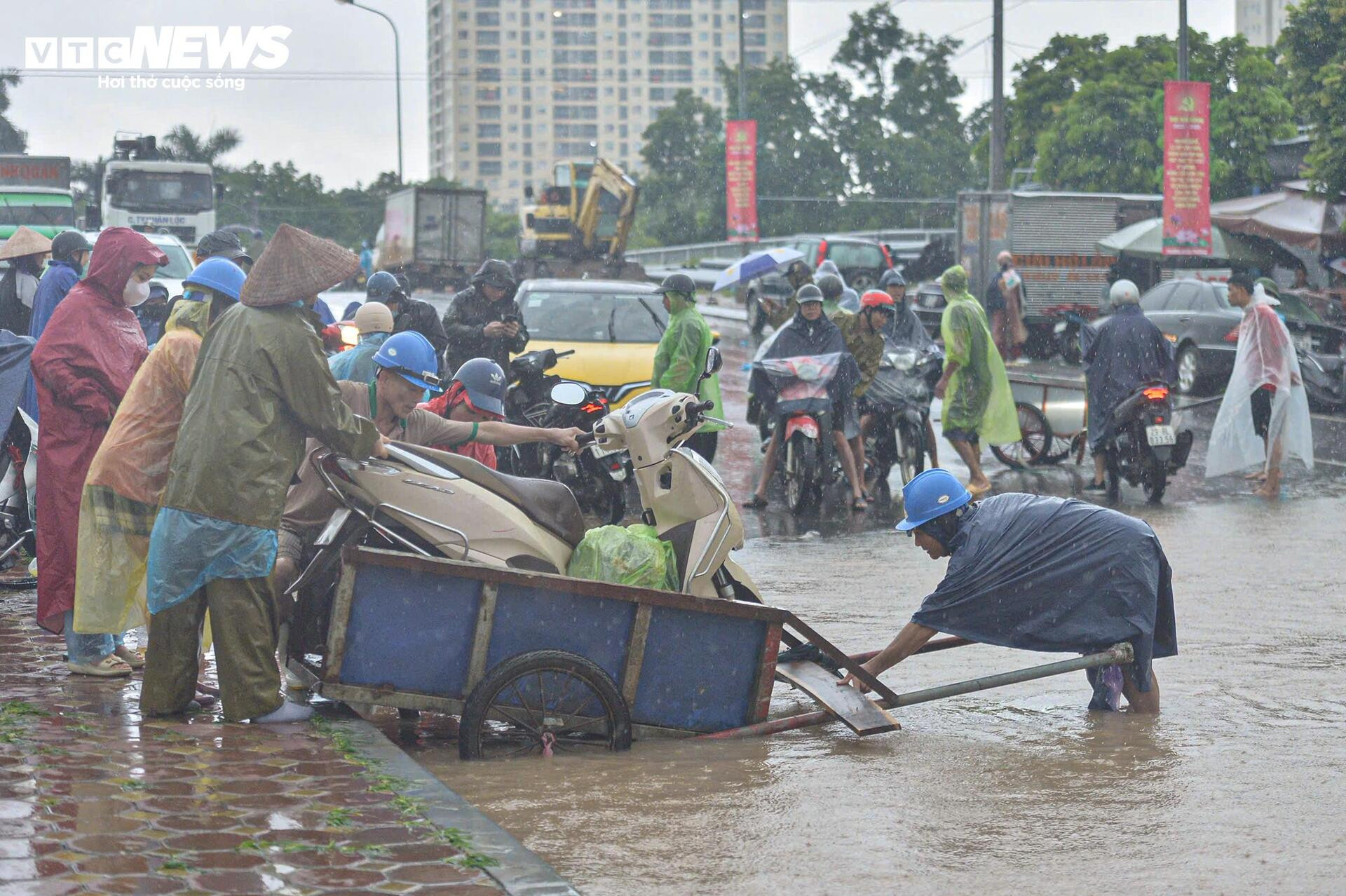 Ngập tới bụng trên quốc lộ, xe kéo 'cõng' xe máy vượt biển nước - 2