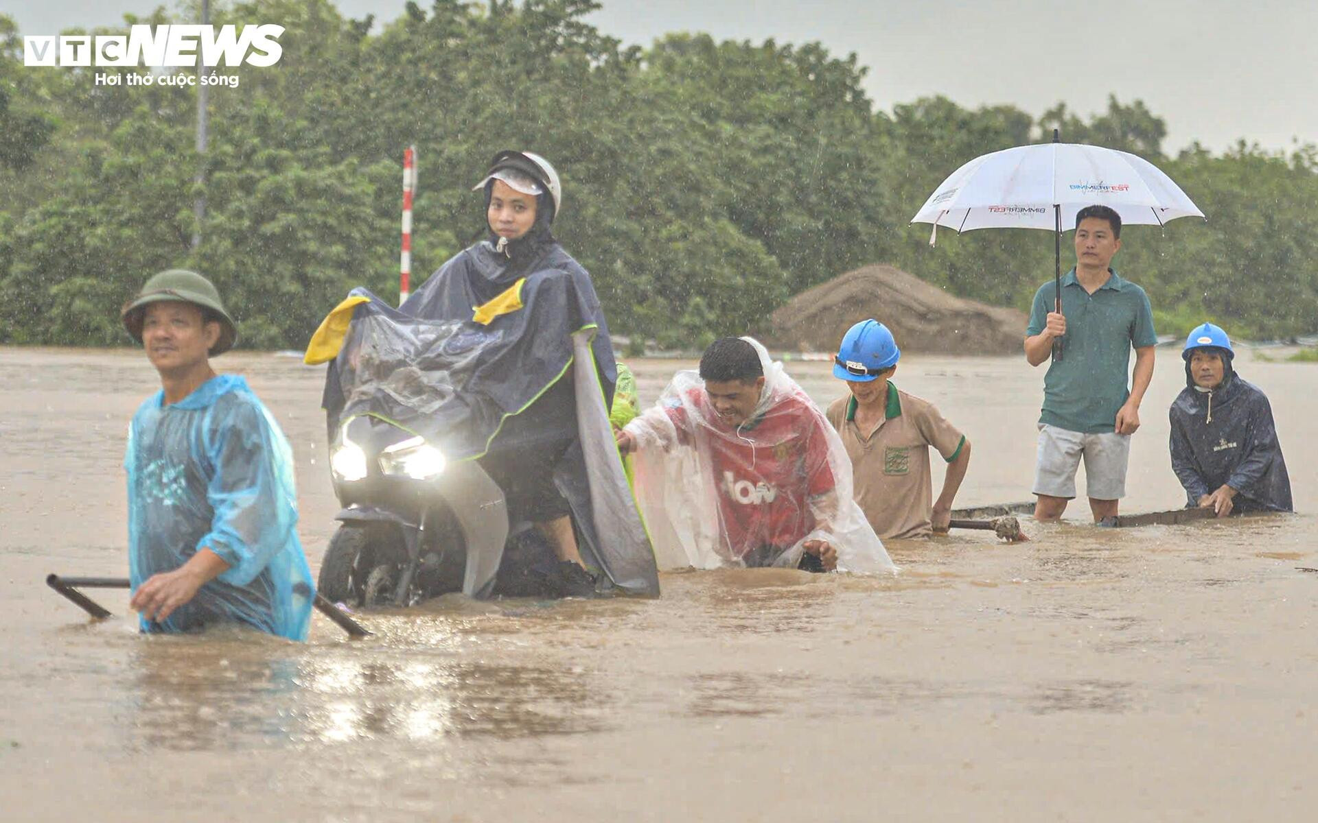 Ngập tới bụng trên quốc lộ, xe kéo 'cõng' xe máy vượt biển nước - 9