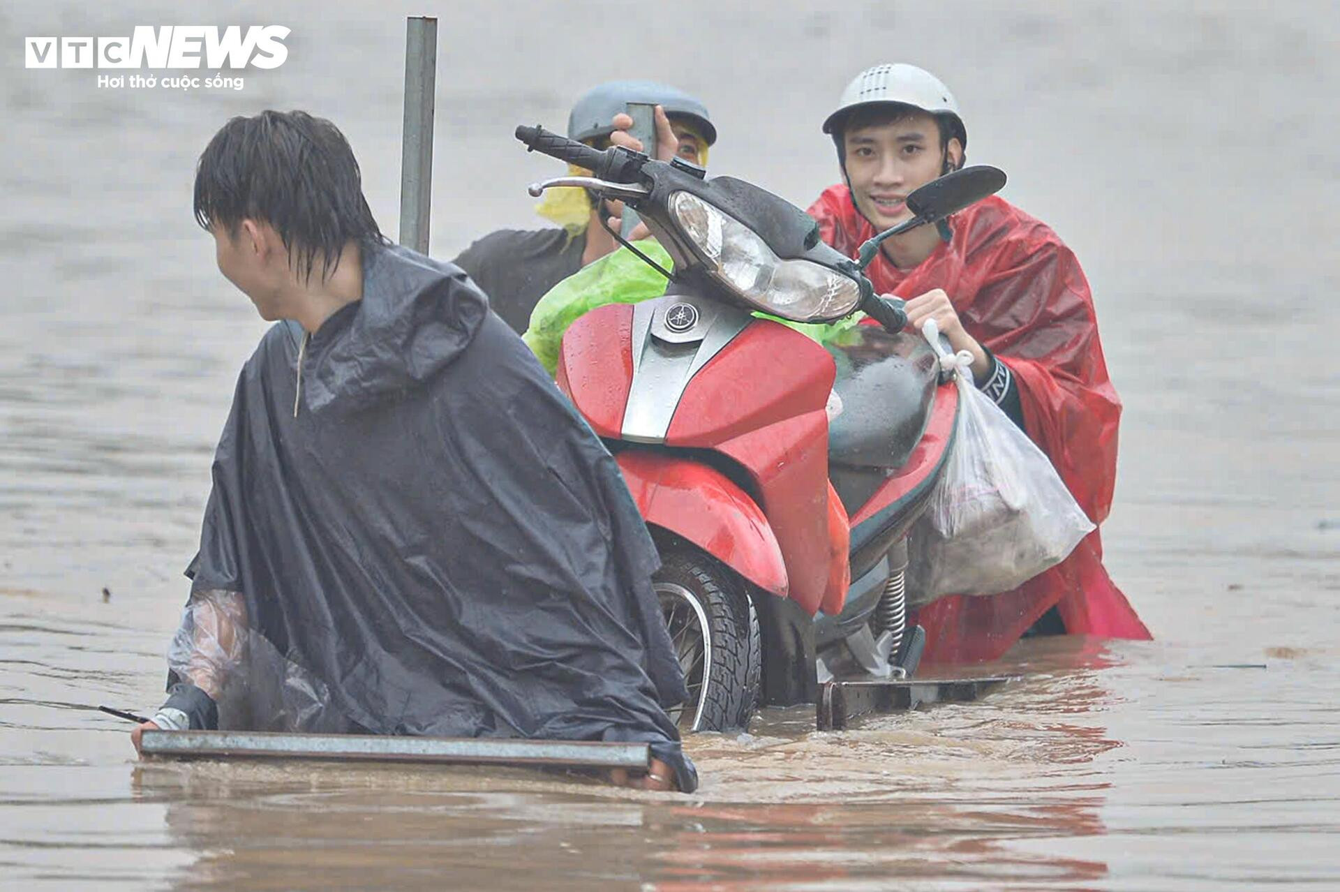 Ngập tới bụng trên quốc lộ, xe kéo 'cõng' xe máy vượt biển nước - 7