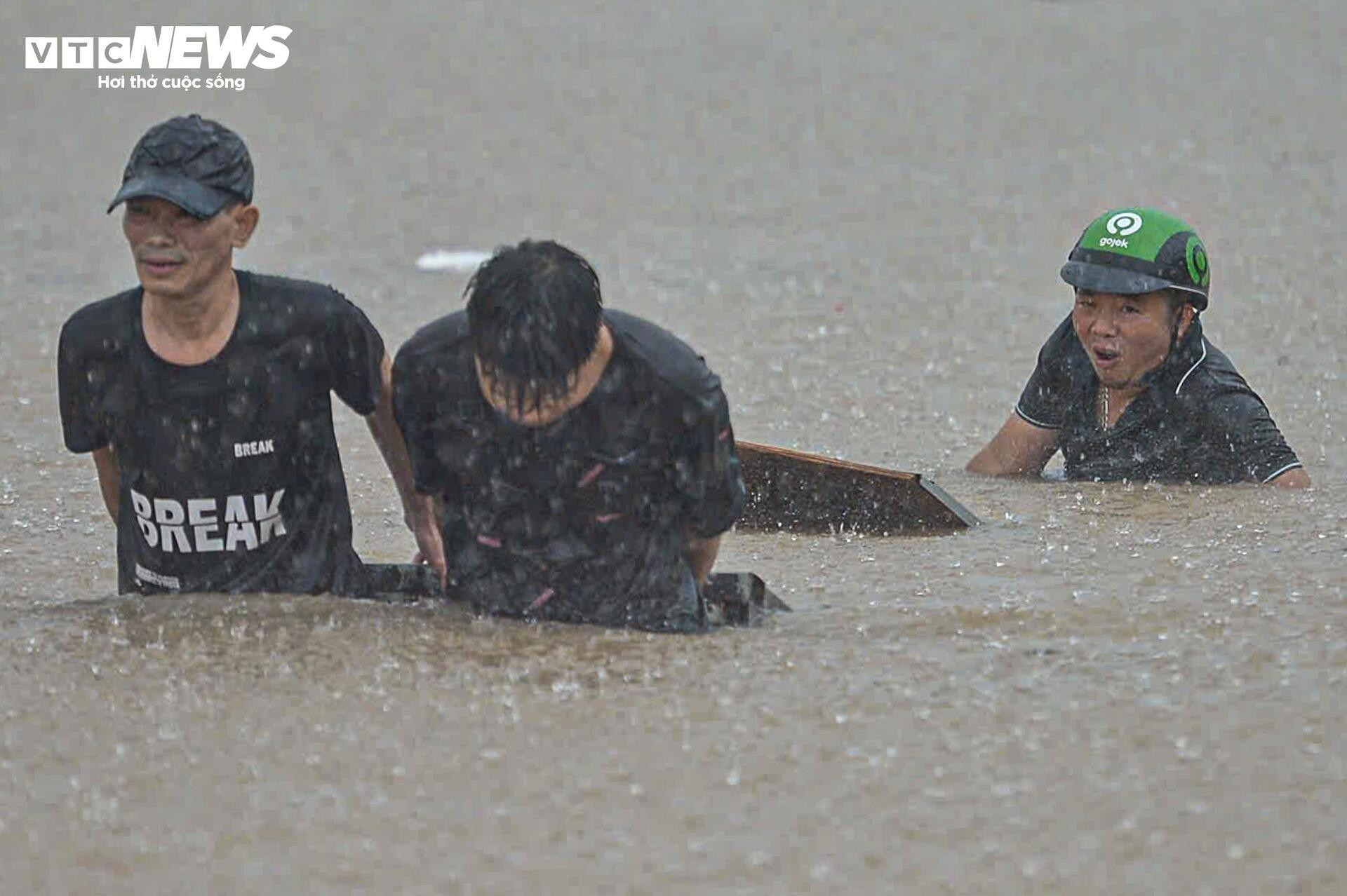 Ngập tới bụng trên quốc lộ, xe kéo 'cõng' xe máy vượt biển nước - 10