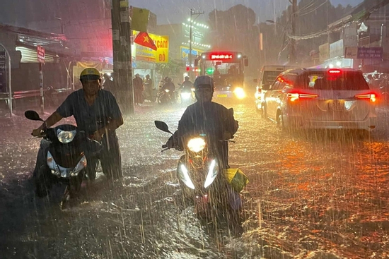 Mưa ngập lút bánh xe, người dân TPHCM vật lộn giữa dòng nước