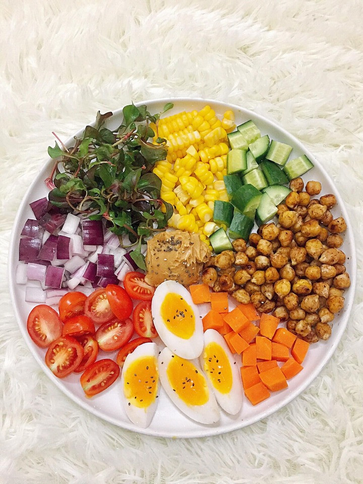 Thực đơn có xà lách xoong Nhật, hành tím, cà chua bi, trứng gà luộc, cà rốt luộc, đậu gà hấp, ngô ngọt hấp, dưa leo.