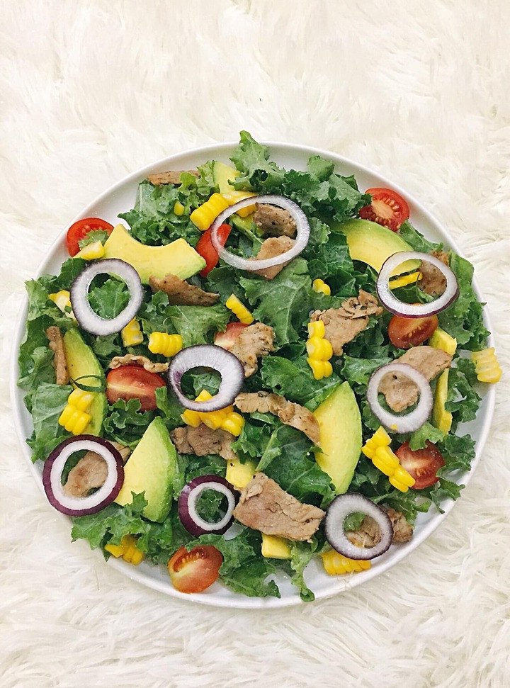 Món salad gồm cải kale, bơ, ngô ngọt, thịt bò, hành tím, cà chua bi.