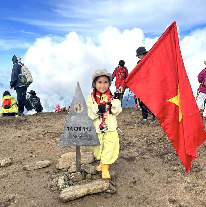 Bé Bơ phất cao lá cờ Việt Nam trên đỉnh Tà Chì Nhù.