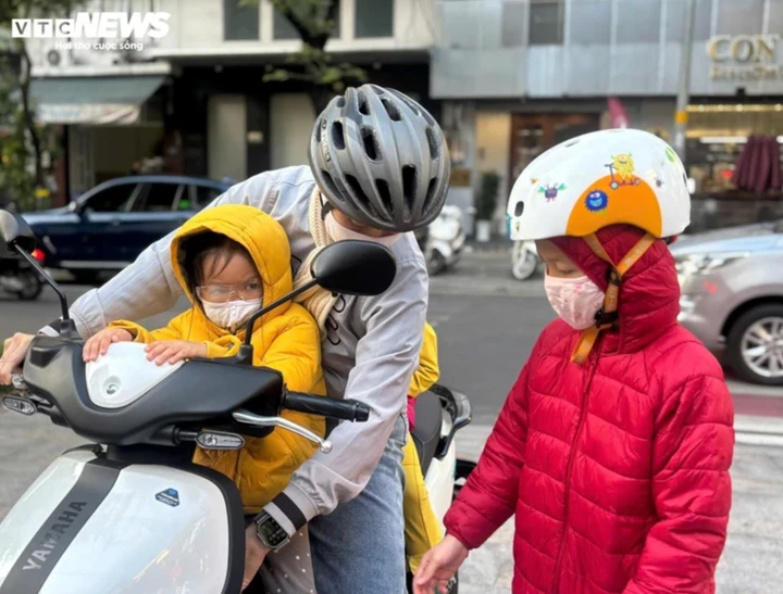 Người dân TP.HCM mặc áo khoác ra đường vào sáng sớm khi nhiệt độ giảm do ảnh hưởng không khí lạnh.