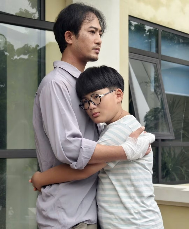 Minh Xíu vào vai Khang, con trai của Bình (Doãn Quốc Đam) và Hạnh (Huyền Lizzie) trong phim “Căn nhà không mái che”.