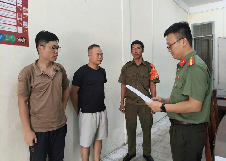 Công an TP Đà Nẵng tống đạt các quyết định đối với Chu Đức Anh (áo đen) và Nguyễn Trung Hiếu (ngoài cùng bên trái). (Ảnh: CA)