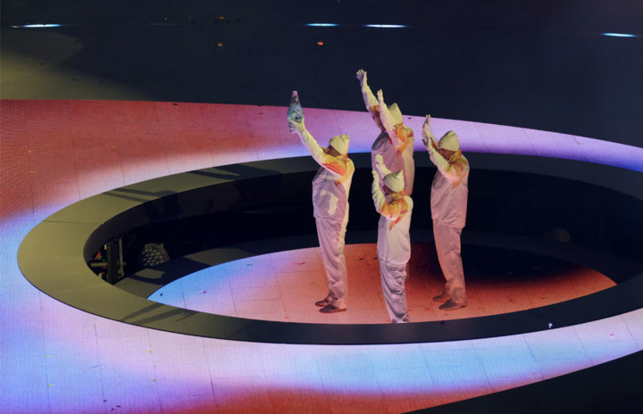 Các cựu VĐV trượt tuyết băng đồng Italy Maurilio De Zolt, Marco Albarello, Giorgio Vanzetta và Silvio Fauner mang ngọn đuốc Olympic vào sân vận động trong lễ bế mạc.