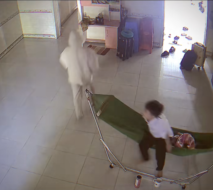 Em trai thấy chị chuẩn bị đi liền đứng dậy khỏi võng.