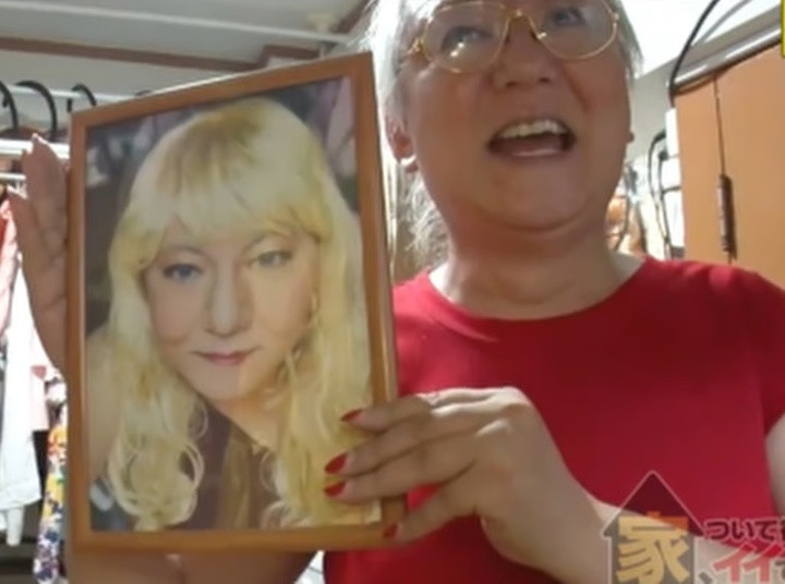 Kuboyama cầm một bức ảnh đóng khung chụp bà hồi trẻ với mái tóc giả màu vàng. (Ảnh: Guancha)