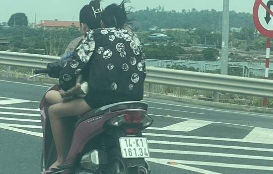 Hai phụ nữ 'đầu trần' lạng lách xe máy trên cao tốc, người ngồi sau ôm búp bê