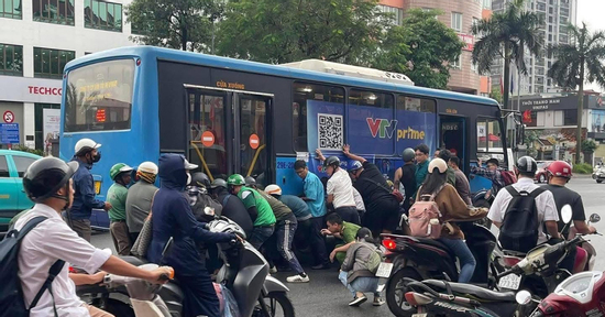Hơn 10 người hợp sức nâng xe buýt để cứu nữ tài xế xe máy bị cuốn vào gầm