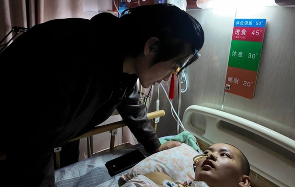Zhang comforts Zhang as she lies stricken in her hospital bed. Photo: Baidu
