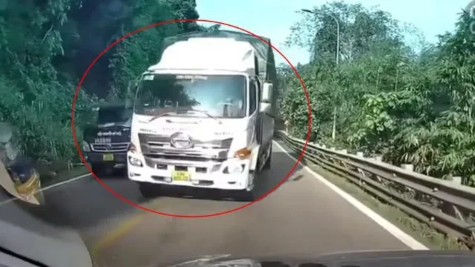 “Mượn” làn đường ngược chiều, xe tải cố ép xe con đi sát ta-luy gây nguy hiểm. Ảnh cắt từ clip quay tại Quốc lộ 20, đoạn qua Bảo Lộc, tỉnh Lâm Đồng năm 2024.