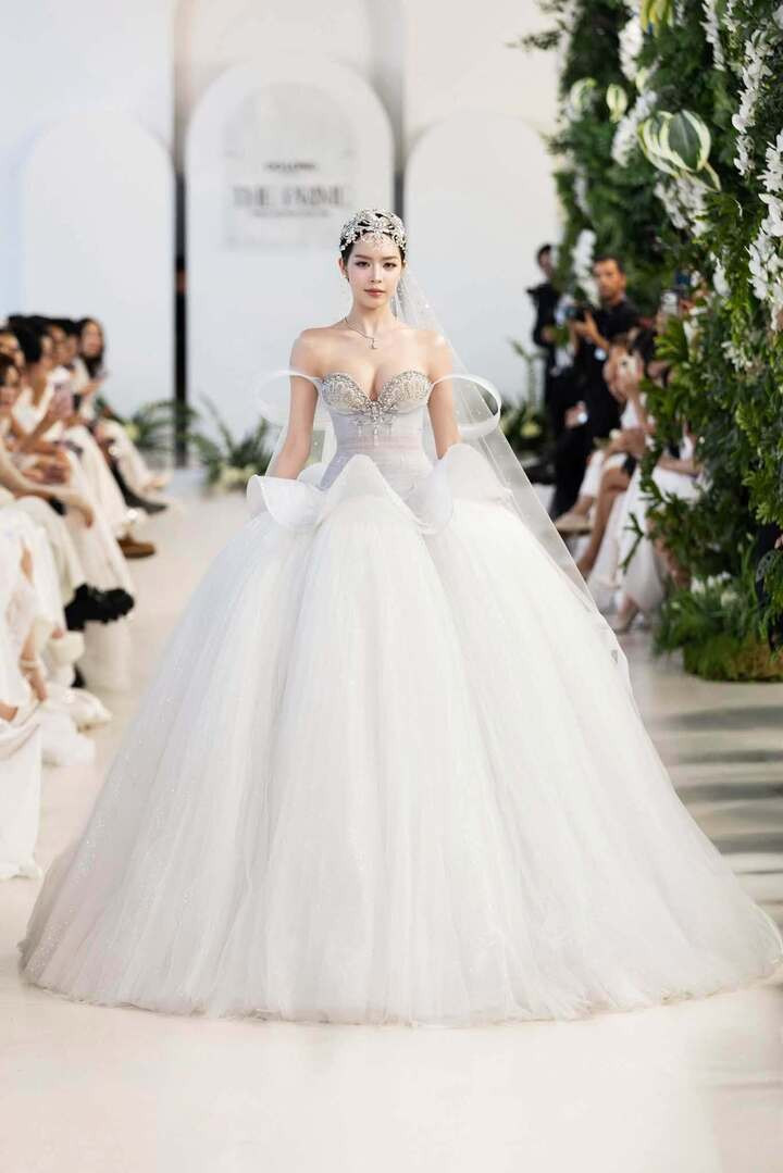 Hoa hậu Thanh Thuỷ đẹp tựa công chúa cổ tích. Nàng hậu diện thiết kế bridal với corset xuyên thấu ôm sát cơ thể, đính kết cầu kỳ và bắt sáng, phối cùng chân váy tulle bồng nhẹ.