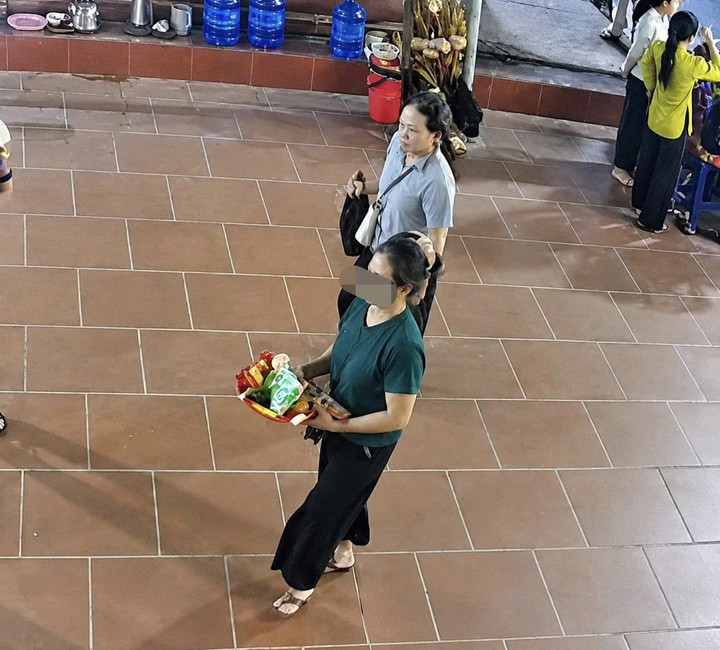 Khi phát hiện người phụ nữ mặc áo xanh để tài sản hớ hênh, đối tượng mặc áo màu ghi tiếp cận để dàn cảnh móc túi. (Ảnh cắt từ clip)