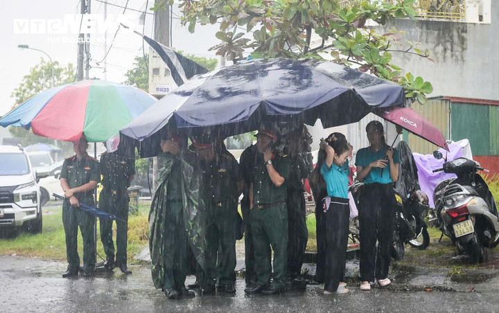 Dưới trời mưa lớn, đoàn người vẫn kiên nhẫn đội mưa chờ vào viếng. (Ảnh: Tiến Thắng)